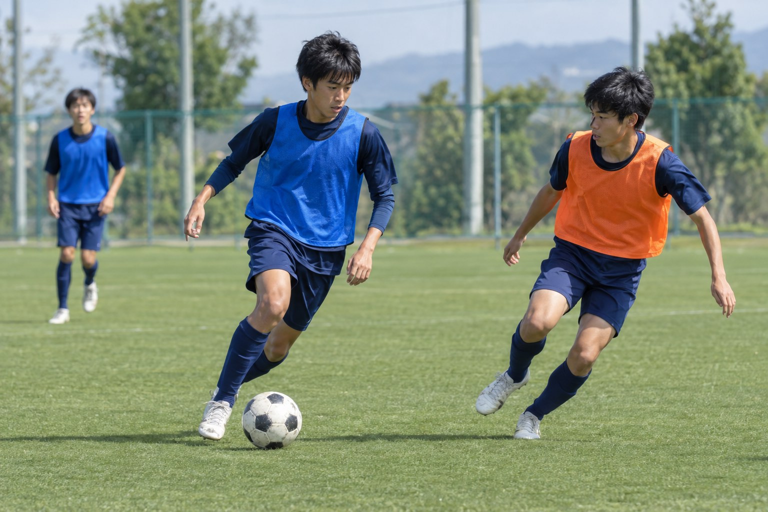ドリブルの種類を練習するサッカー選手が相手をかわしてボールを運ぶ場面